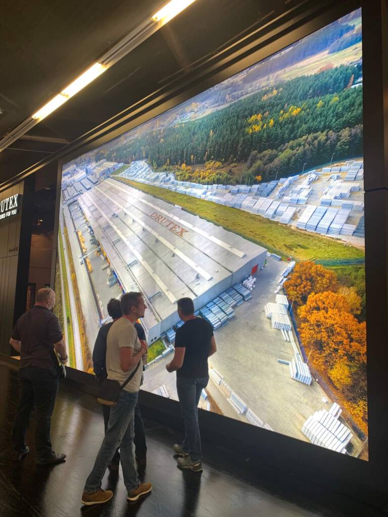 ludzie patrzący na projekcję budynku hangaru firmy drutex z lotu ptaka