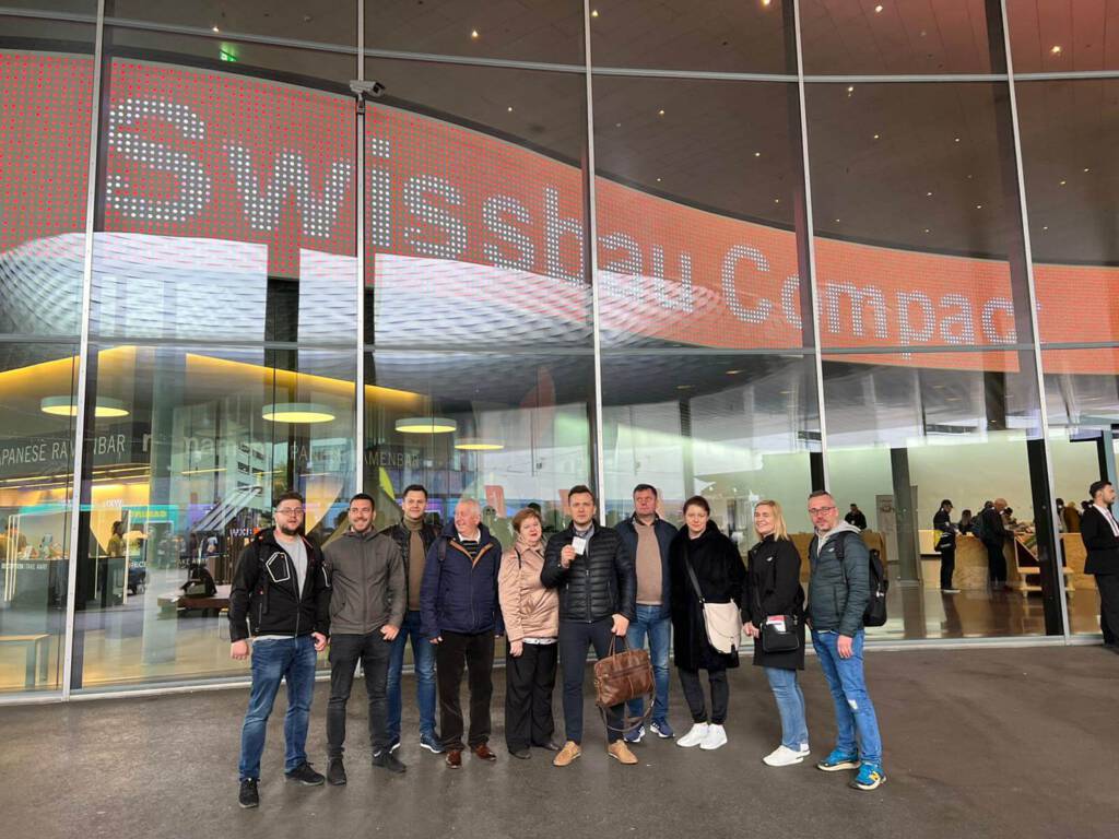 ludzie pozujący do zdjęcia na tle swissbau compact