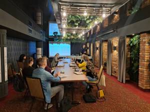 ludzie siędzący przy stole podczas prezentacji